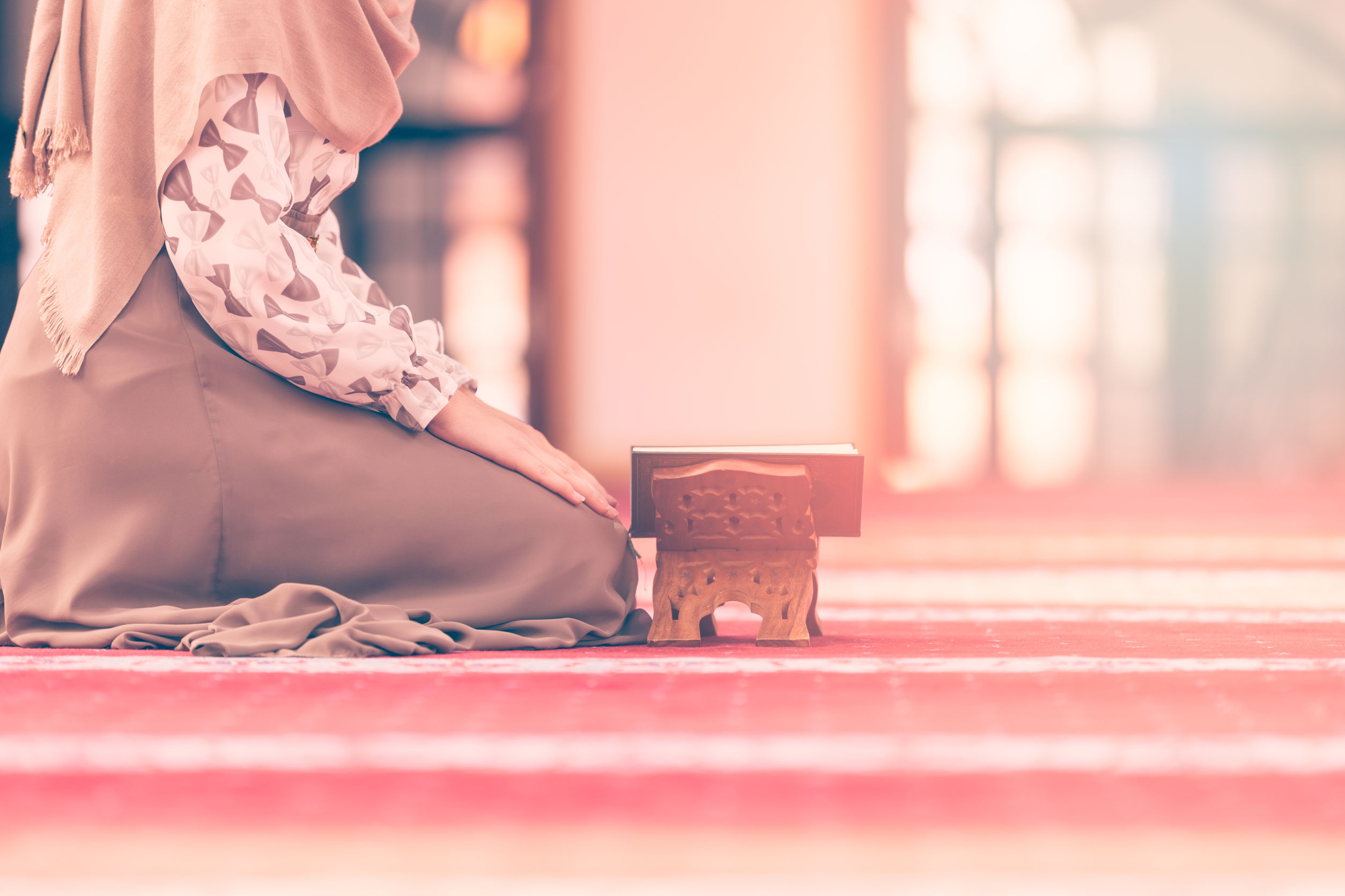 67568040 - young muslim woman reading koran in mosque.